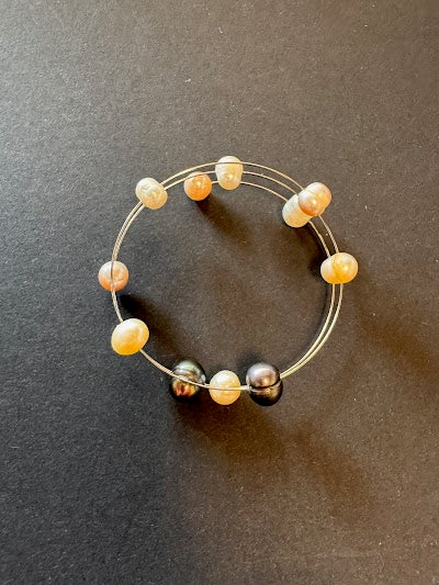 Flexible white, golden and peacock-hued pearl bracelet