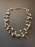 Multi-stranded 'floating' white pearl necklace on monofilament strands
