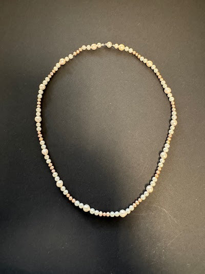 Long white and golden-hued pearl necklace