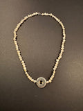 Silver metal disc and white pearl necklace