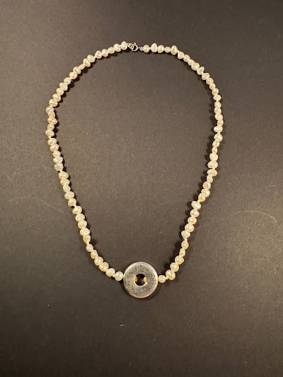 Silver metal disc and white pearl necklace