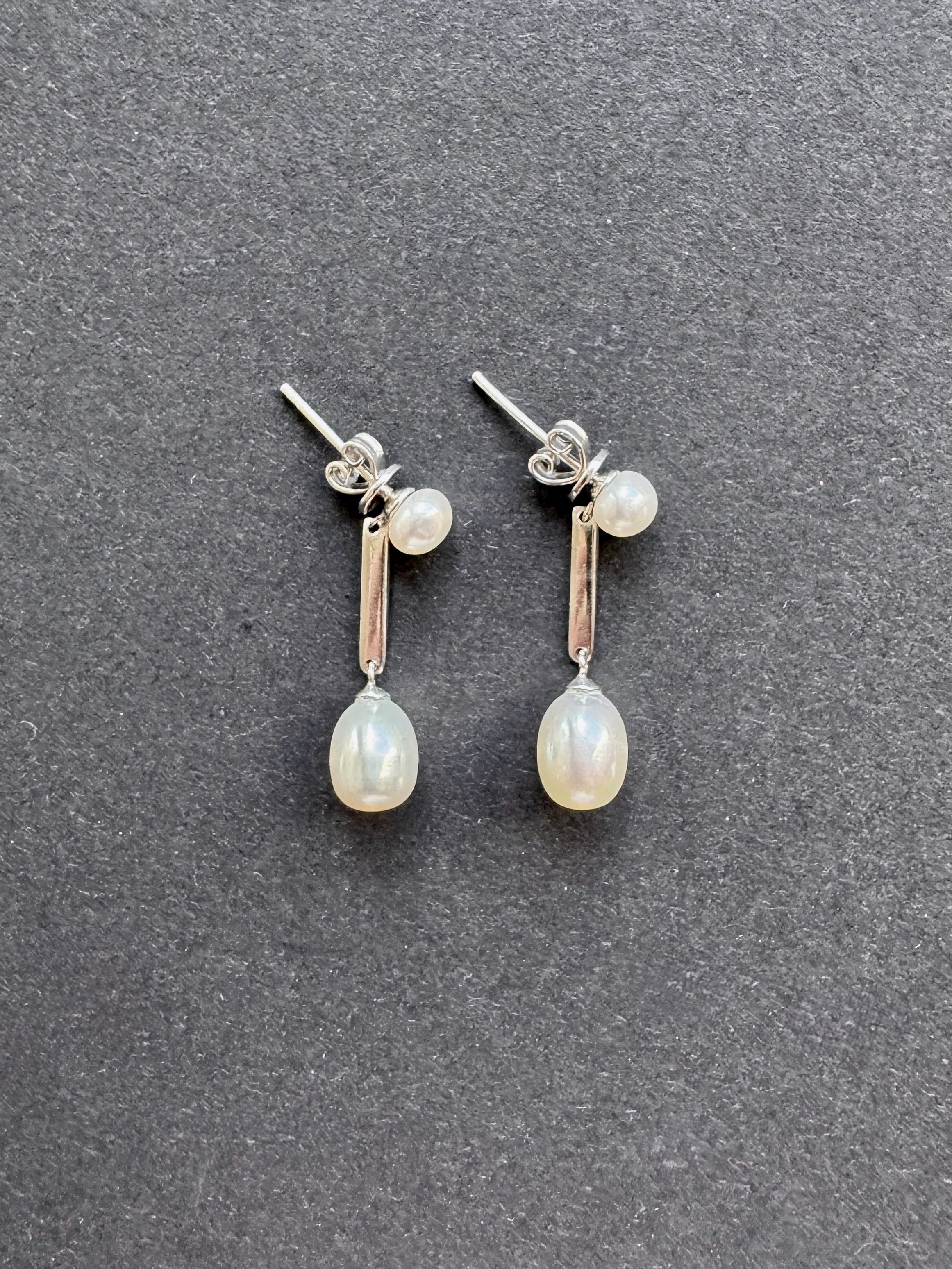 White oval pearl earrings on a pearl and sterling silver post