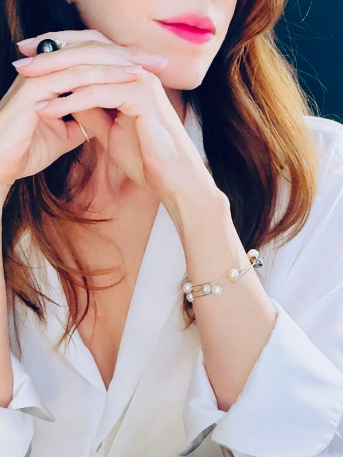 Flexible white, golden and peacock-hued pearl bracelet